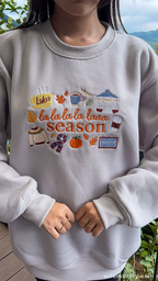 Model showcasing a light gray La La La Season autumn sweater in a outdoor natural setting.