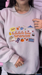 Model wearing an oversized beige La La La Season embroidered crewneck sweatshirt indoors.