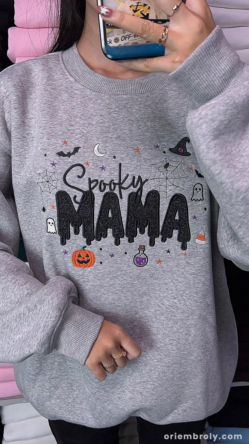 Model wearing an oversized gray Spooky MAMA embroidered sweatshirt indoors.