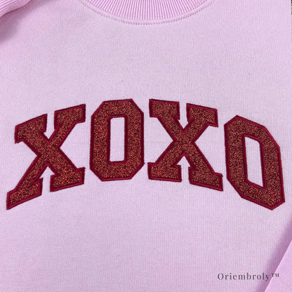 Varsity-style XOXO embroidery with subtle glitter texture